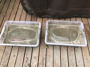 I notices that the moulds - when resting on a flat surface - would deform a little under their own weight.  So I immersed them in wet cement+sand so that a support would be created with the moulds in their relaxed state. 