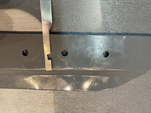Made a notched too out of 1.2mm 6061-T6 which is inserted from the topcoated side (interior) and twirled around the hold, pulling and angled slightly so as to tear away the adhesive layer.