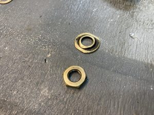 The brass got really thin at the edges of the stepped washer, these edges were filed straight. This also permits a spanner to be used to prevent the washer from spinning as the nut is tightened.